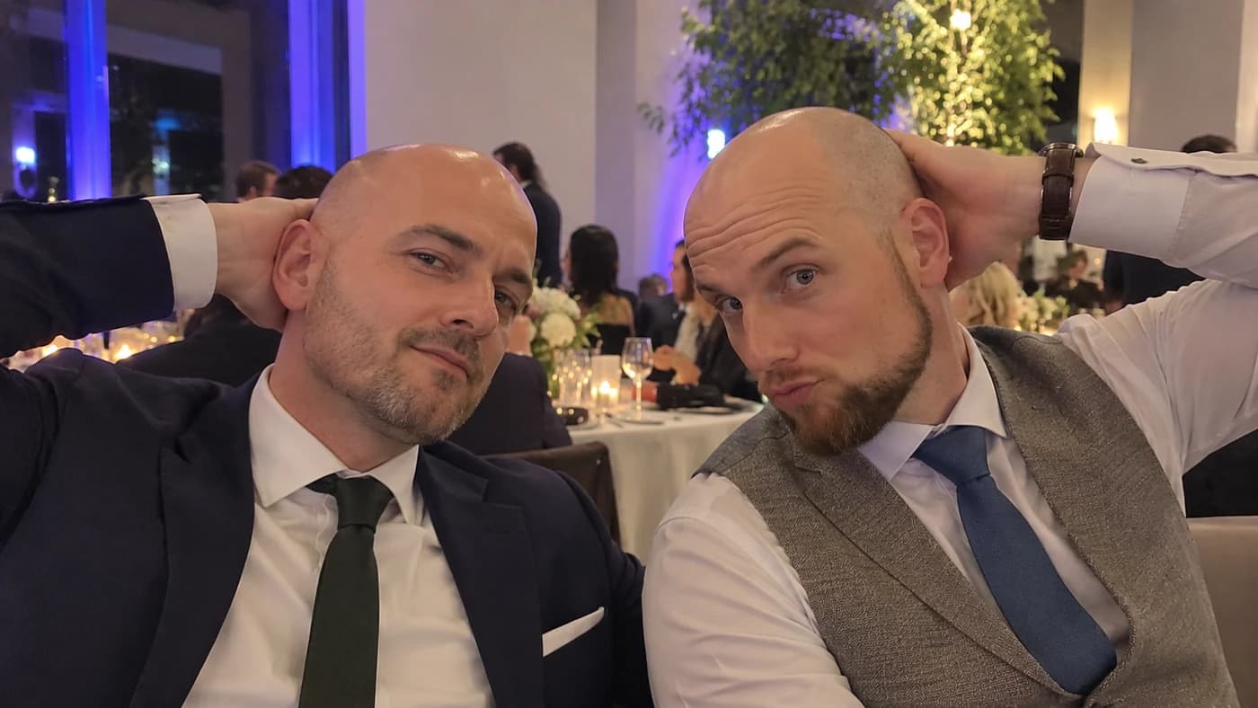 Zwei Gäste mit Glatze machen bei einer festlichen Feier ein Selfie