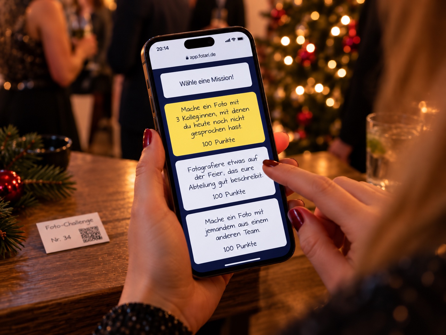 Gast wählt auf dem Smartphone eine Fotoaufgabe für die Weihnachtsfeier aus
